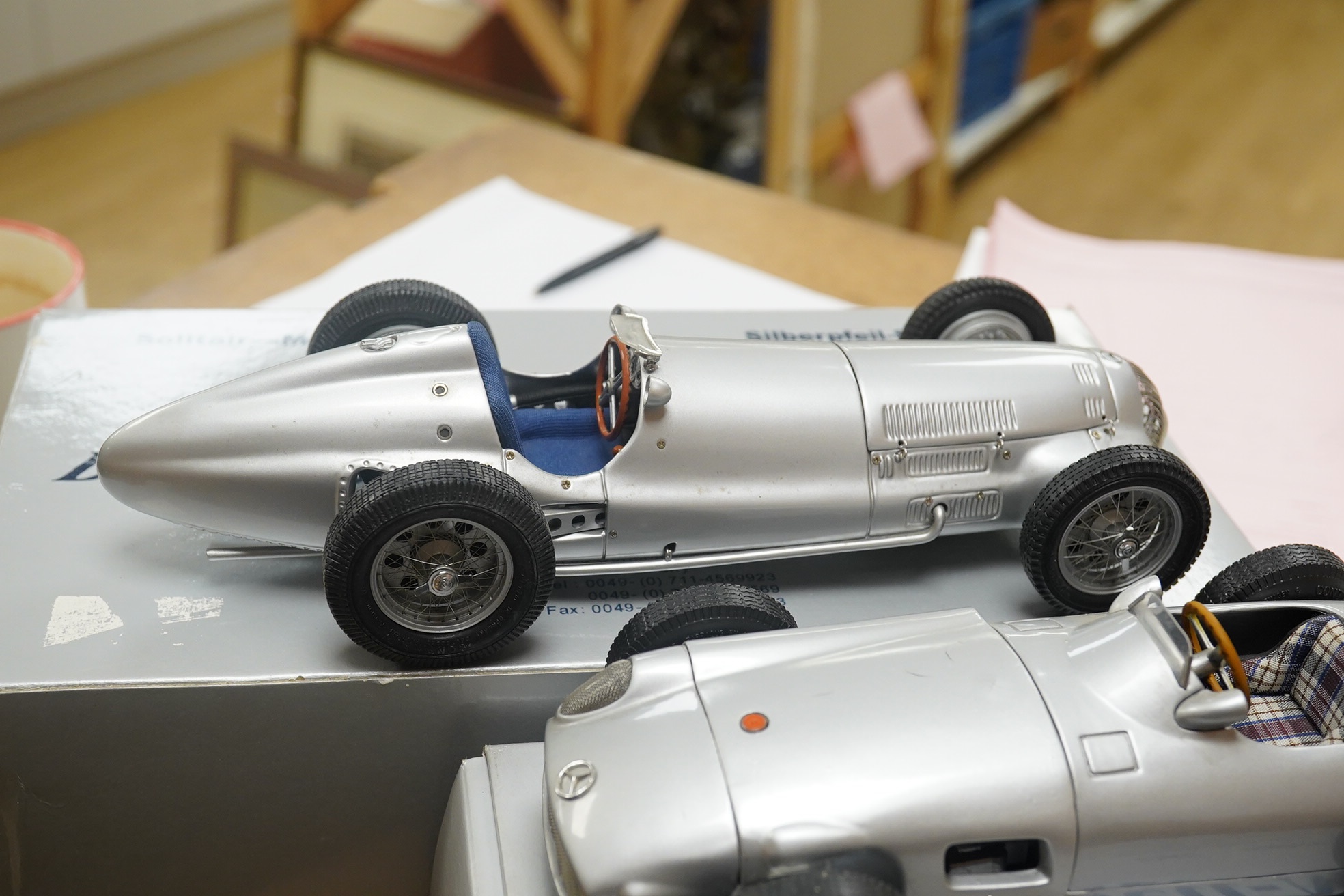 Two boxed CMC 1:18 scale diecast model cars; a Mercedes-Benz W196, together with a Mercedes-Benz W154 1938. Condition - fair to good, and slight metal fatiguing to the bonnet on the W196 as occasionally found with early